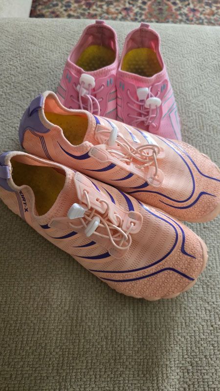 Peach and purple barefoot shoes shown in front of a pink pair, highlighting flexible soles and breathable design