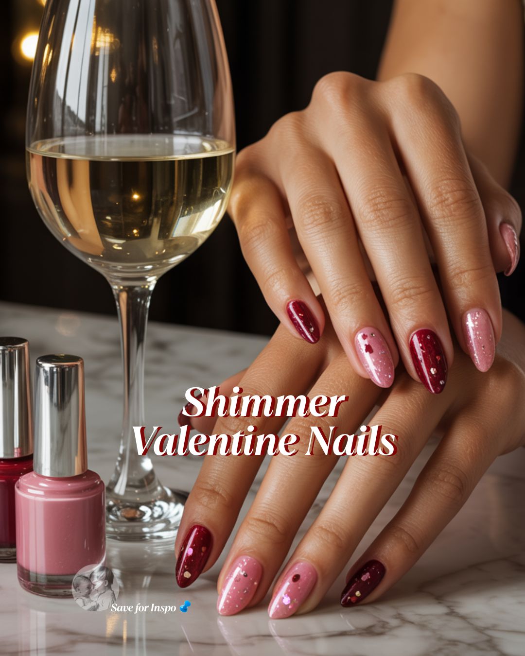 Valentine’s Day manicure featuring glossy red and pink shimmer nails styled with a wine glass and nail polish bottles on a marble surface.
