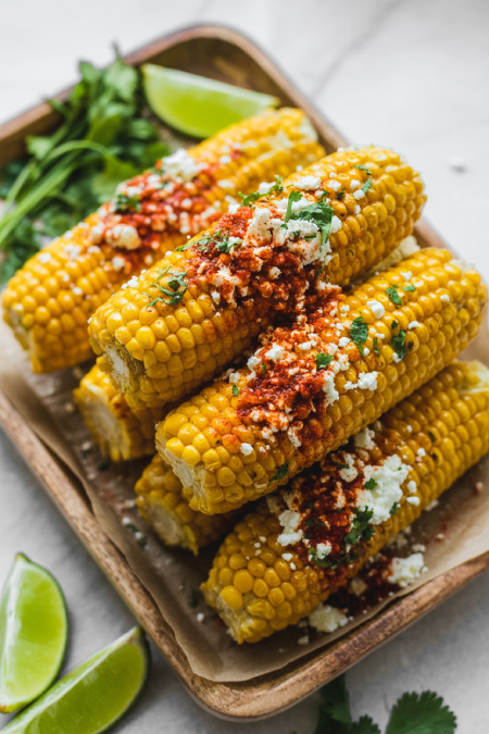 mexican street corn with cheese chili lime and cilantro on serving tray