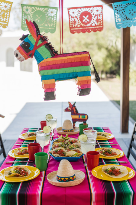 Cinco de Mayo table decor with hanging piñata colorful plates and fiesta decorations