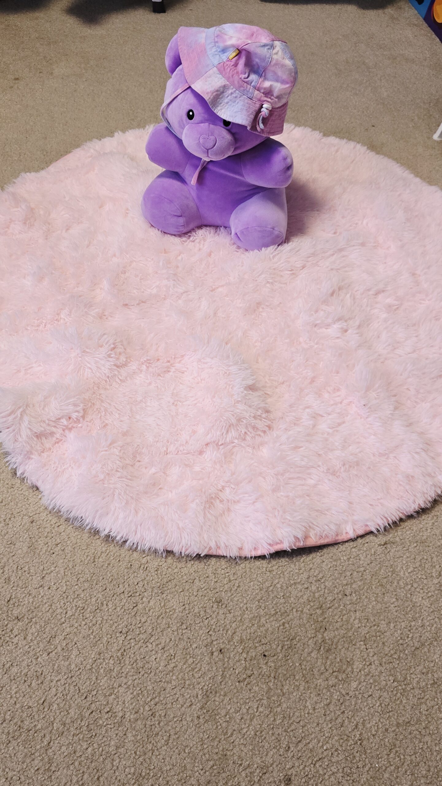 Pink fluffy round rug in girls room makeover with soft shag texture used for cozy seating and play area