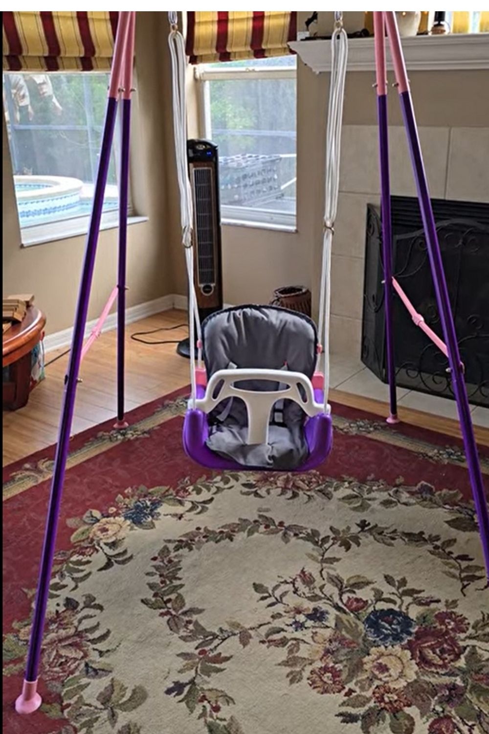 Pink and purple toddler swing with frame for indoor or outdoor use in girls play area